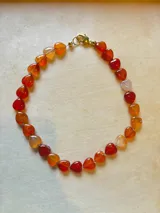 Collar de cuentas de ágata natural talladas en forma de corazón, con cierre metálico dorado.
