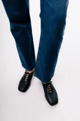 Zapato acordonado de cuero color negro, de diseño minimalista con punta cuadrada y silueta moderna.