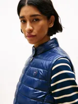 Chaleco azul marino con relleno de plumón, cuello mao y cierre frontal con cremallera.