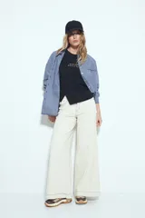 Remera blanca de manga corta con cuello redondo, aberturas laterales y bordado frontal con la frase "LIMITED EDITION" en negro.