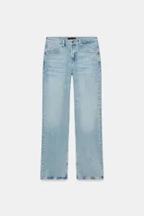 Jeans de tiro medio con diseño de cinco bolsillos, cierre frontal con cremallera y botón, en tono celeste con efecto deslavado.