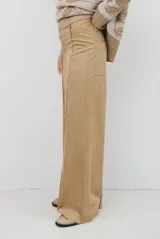 Pantalon de corte recto y tiro alto, confeccionado en un tejido de acabado suave y textura aterciopelada, con costuras verticales decorativas en el frente.