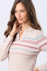 Remera tipo polo de manga larga confeccionada en rib de algodón. Presenta un diseño a rayas horizontales en tonos pastel sobre fondo blanco, con cuello polo y escote en V sin botones.