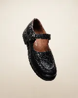 Mocasín de cuero natural color marrón, con costuras visibles, hebilla lateral metálica y solapa desmontable con flecos.
