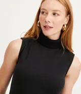 Vestido midi negro de suedine, sin mangas, con cuello alto acanalado y aberturas laterales.