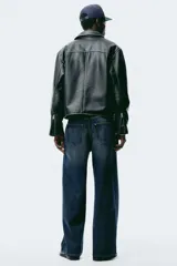 Jean de cinco bolsillos en denim de algodón rígido, color azul oscuro. Modelo de corte holgado de cadera a bajo con pierna amplia y tiro caído. Cintura estándar y cierre.