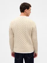 Buzo de tejido de punto con diseño de trenzas verticales, cuello redondo y puños y ruedo acanalados.