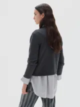 Polera de punto en color celeste, con cuello alto y manga larga. Presenta un pequeño logo bordado en el centro del pecho y terminaciones en tejido acanalado.