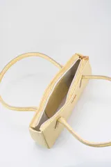 Cartera tipo baguette color negro con textura efecto cocodrilo, diseño alargado, doble asa de mano y cierre superior.