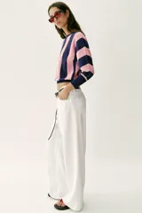 Sweater de punto con diseño de rayas verticales anchas en color azul marino y rosado, cuello redondo y mangas largas con puños ajustados.