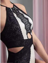 Body blanco con paneles de encaje negro, escote halter con abertura en el pecho y espalda descubierta.