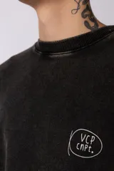 Buzo de cuello redondo con calce oversize y efecto lavado (washed). Presenta una estampa gráfica en la espalda con el diseño de una copa de martini y texto descriptivo.