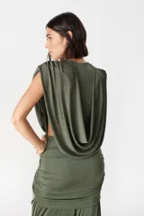 Vestido largo de fiesta color verde oliva, con escote profundo drapeado y falda con frunces laterales que aportan movimiento y caída fluida.