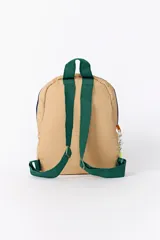 Mochila de color beige con diseño capitoneado hexagonal. Presenta un compartimento principal y un bolsillo frontal con cierres en contraste de colores azul y naranja, además de tiradores de cordón decorativos.