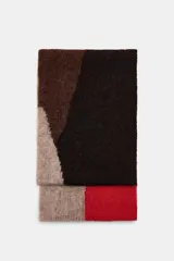 Bufanda de punto con diseño geométrico de bloques de color en tonos marrón, negro, beige y rojo. Confeccionada en una mezcla de fibras que incluye alpaca y lana.