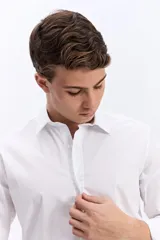 Camisa de manga larga blanca con calce semi slim, cuello camisero, cierre frontal con botones y logo bordado al tono en el pecho.