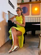 Vestido largo color lima con cuello halter, espalda descubierta, abertura lateral en la falda y recorte en la cintura.