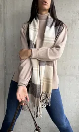 Polera beige de cuello alto y manga larga.