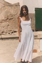 Vestido midi de popelín color blanco, con escote cuadrado y tirantes anchos. Presenta un diseño con godets que aportan volumen a la falda y cierre lateral con cremallera oculta.