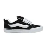 Championes Vans modelo Knu Skool, diseño de estilo retro con silueta abullonada, color negro con la icónica banda lateral blanca, cordones gruesos y suela de goma vulcanizada.