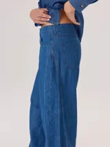 Pantalon de jean ancho, de corte holgado y fluido desde la cadera hasta el tobillo, con costuras verticales decorativas en el frente.