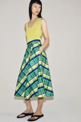Falda midi de tiro medio marca ZWE Collection, confeccionada en hilatura de algodón con diseño de cuadros tipo tartán en tonos verdes, azules y amarillos. Tiene corte evasé y cierre lateral con cremallera oculta.
