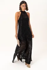 Vestido largo de encaje negro con destellos de lurex, diseño de cuello halter y tajos laterales. Incluye un vestido corto removible como forro interno.