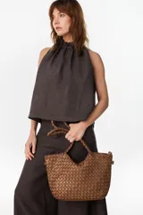 Cartera de cuero marrón con diseño trenzado y asas de mano rígidas, de estilo atemporal y versátil.