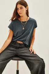 Remera de algodón color azul oscuro o gris pizarra, de corte holgado y manga corta con el dobladillo doblado hacia arriba.