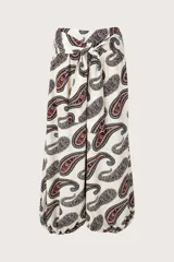 Pantalón de corte fluido color beige con estampado paisley en tonos oscuros, tiro alto con lazo para anudar en la cintura y botamangas con elástico.
