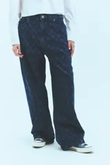 Jean de tiro bajo y corte oversize, confeccionado en denim azul con grabado láser de monograma en patrón de rombos. Presenta avíos metálicos y diseño de pierna ancha.