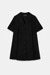 Vestido corto de algodón con cuello solapa, manga corta y cierre frontal con botones. Presenta un diseño evasé con bolsillos laterales ocultos en las costuras.