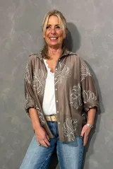 Camisa de seda color visón con diseño bordado en relieve de hojas grandes en color crudo, de manga larga y corte oversize.