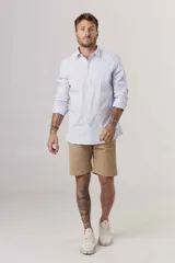 Camisa de manga larga para hombre, color celeste claro con finas rayas verticales blancas. Corte ajustado (slim fit) y cuello clásico.