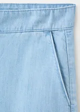 Short de denim suave color celeste claro, de tiro bajo, silueta recta y largo midi, con diseño de cinco bolsillos y costuras frontales marcadas.