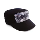 Gorra estilo militar color negro, con un parche rectangular cosido a mano con hilo blanco. El parche presenta un diseño gráfico con tipografía estilo death metal sobre un fondo con textura tipo camuflaje.