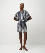 Short femenino de viscosa y poliamida, con estampado de rayas verticales blancas y azul marino. Presenta un modelo corto, cintura elástica y cierre de botón.