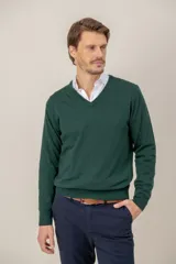 Sweater de lana merino color verde oscuro, con cuello en V y puños y ruedo acanalados.