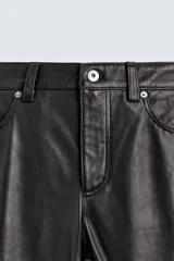 Pantalón slim fit confeccionado en piel, con diseño de cinco bolsillos, cierre frontal de cremallera y botón.