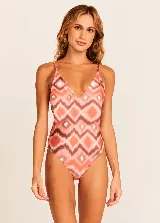 Traje de baño enterizo con estampado geométrico en tonos naranja, marrón y blanco.