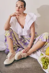 Zapatillas grises con cordones y suela blanca.