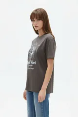 Remera de algodón manga corta, corte holgado, con cuello redondo y estampado frontal en negro con la frase "Travel through the universe" y motivos celestes de sol, luna y estrellas.