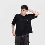 Remera negra de corte oversize, confeccionada en algodón premium con textura suave. Presenta un diseño minimalista con una pequeña estampa de texto en el pecho.