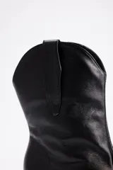 Botineta estilo texano de cuero vacuno color negro, con taco cuadrado y punta fina.