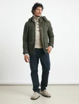 Pantalón cargo de algodón sarga con elastano, color verde militar. Presenta bolsillos laterales con fuelle, bolsillos traseros con tapa y botón, y costuras reforzadas en las rodillas.