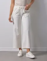 Pantalón jogger color crema, de corte ancho, con pretina elastizada y lazo de ajuste.