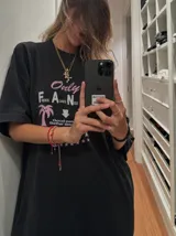 Remera oversize marrón con estampado gráfico frontal en tonos celestes y blancos con la leyenda "Only Fans", palmeras y estrellas.