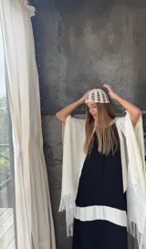 Ruana tejida a mano en hilo de color azul marino, con diseño de punto calado y terminación de flecos en los extremos.