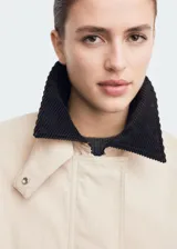 Chaqueta oversize color beige con cuello camisero de pana en contraste color negro. Presenta cierre frontal oculto con cremallera y botones, manga larga y bajo con cordón interior ajustable.