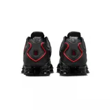 Championes Nike Shox TL con diseño icónico y amortiguación mecánica en color negro con detalles en rojo. Cuenta con capellada de malla transpirable, estructura de TPU y suela de goma.
